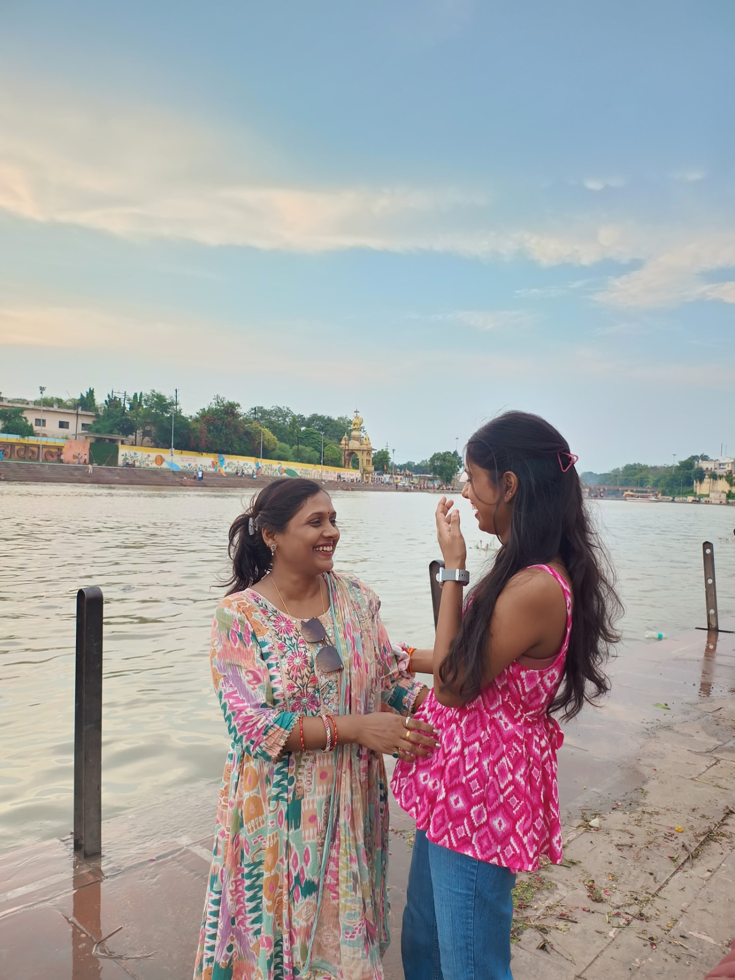 Aradhya laughing with her mother by the riverbank
